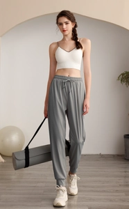 Detail of high waist grey drawstring jogger pants with white v-neck yoga tank top