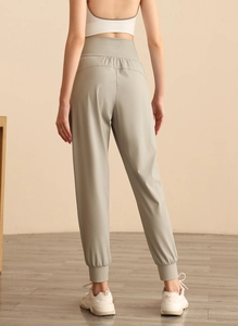Dettaglio della vita alta e delle cuciture lisce dei pantaloni jogger verdi dal retro