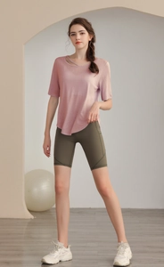 Detailed view of pale pink yoga top with unique diagonal hollow neckline and slim fit