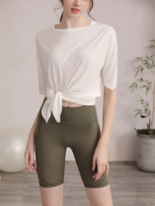 Détail du t-shirt de sport blanc avec nœud frontal et short de fitness taille haute olive