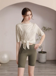 Détail du haut de yoga beige avec nœud et ensemble de short de cycliste vert olive