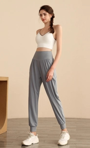 Dettaglio dei joggers in nylon a vita alta e reggiseno sportivo bianco per yoga e fitness