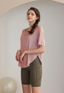 Pink tencel yoga tee and olive green high-waisted shorts set in a minimalist studio