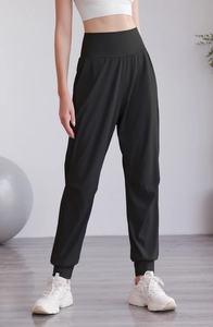 Dettaglio dei joggers neri da yoga a vita alta con polsini elastici e fascia larga da donna