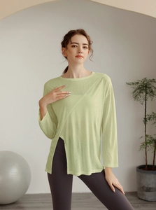 Détail du haut de yoga vert clair avec fente latérale et coutures asymétriques