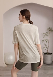 Vue arrière du t-shirt de yoga beige ample et du short cycliste vert en studio moderne