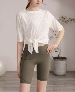 Ensemble de sport pour femme avec t-shirt noué blanc et short cycliste olive