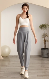 Dettaglio dei pantaloni sportivi grigi a vita alta con tessuto morbido e polsini elastici