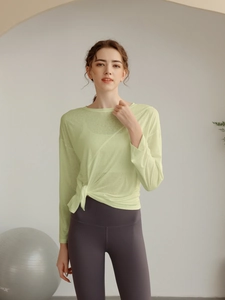 Détail du haut de yoga vert clair semi-transparent avec nœud latéral élégant