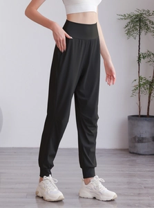 Dettaglio dei pantaloni sportivi neri a vita alta con polsini elastici e vestibilità slim
