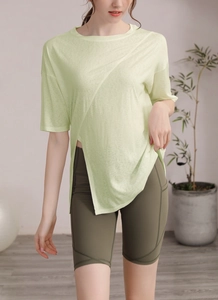 Détail du t-shirt de yoga vert clair à ourlet asymétrique et du short de cyclisme olive