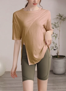 Détail d'un t-shirt de yoga beige ample avec fente latérale et texture de tissu respirant