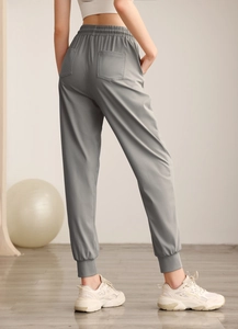 Detailed back view of high-waist grey nylon joggers featuring two functional rear pockets