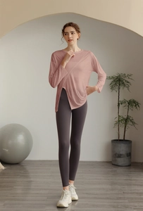 Détail du haut de yoga rose à manches longues avec fente latérale et tissu transparent