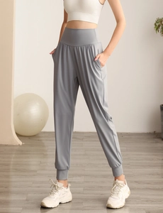 Dettaglio dei pantaloni sportivi yoga a vita alta con tasche laterali e polsini a costine