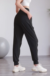 Dettaglio dei joggers neri a vita alta con ampia fascia e tasche laterali pratiche