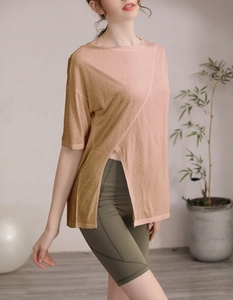 Détail du haut de sport rose avec fentes latérales et short de yoga olive taille haute
