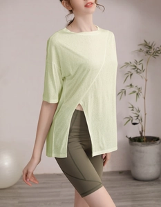 Détail du haut de yoga vert clair avec fente asymétrique et texture en tricot