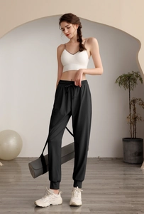 Detail of high-waisted black joggers with adjustable drawstring and breathable fabric