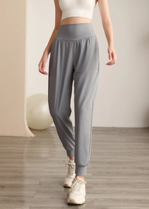 Dettaglio dei pantaloni sportivi grigi a vita alta con tessuto elastico e polsini alle caviglie