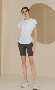 Detailed full-body shot of breathable white fitness tee and olive green yoga biker shorts