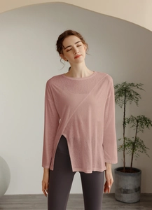 Détail du haut de yoga rose avec fente latérale asymétrique et col rond élégant