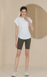 Detail of white breathable short sleeve yoga top with curved hem and olive green biker shorts