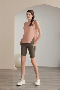 Gilet sportivo rosa senza maniche con spacchi laterali e pantaloncini da ciclista verde oliva