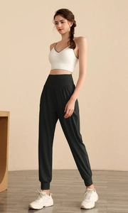 Dettaglio dei pantaloni sportivi neri a vita alta con polsini elastici sulle caviglie e slim