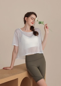Dettaglio del top da yoga bianco trasparente con pantaloncini da ciclismo verde oliva