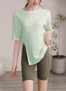 Détail du haut de yoga vert clair avec ourlet asymétrique et short cycliste vert