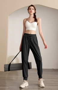 Detail of high waist joggers with drawstring and white sports bra on a model
