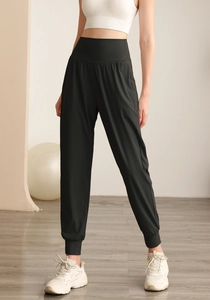 Dettaglio dei pantaloni sportivi neri a vita alta con polsini elastici per yoga e fitness