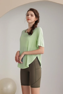 Detail of high-slit yoga top and high-waisted olive shorts with side pockets