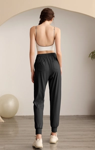Detail view of high waist drawstring athletic joggers with functional back pockets in black