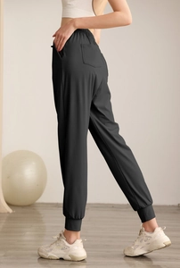 Detail of high waist black joggers showing elastic waistband and functional back pocket