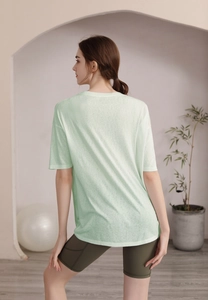 Vue arrière d'un t-shirt de yoga vert clair avec tissu respirant et drapé décontracté