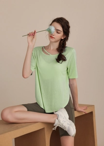 Detail of light green yoga t-shirt featuring a stylish cutout neckline with cross straps
