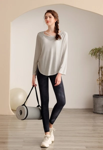 Détail du col croisé sur haut de yoga gris clair avec leggings à imprimé tie-dye
