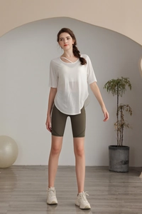 Close-up of white Tencel yoga top with unique cross-strap neckline and curved hem detail