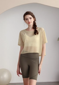 Dettaglio del top sportivo giallo trasparente e pantaloncini da ciclista verde oliva