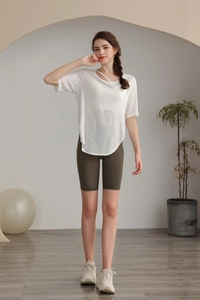 Slim fit white tencel yoga top with asymmetrical neckline and olive green biker shorts