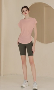 Detailed view of pink breathable yoga top with slim fit ruching and green biker shorts