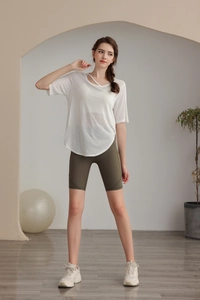 Detail of white yoga top featuring a unique criss-cross hollow neckline design