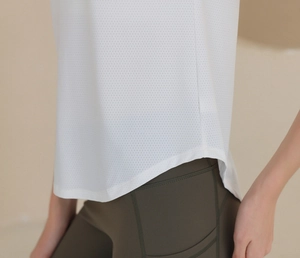 Détail d'un haut de yoga en mesh blanc et d'un legging taille haute vert olive avec poches