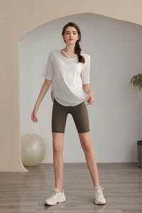 Detailed view of white yoga top with breathable cross cutout neckline for women