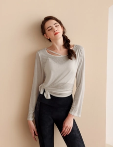 Détail du haut de yoga gris avec décolleté croisé et design à nœud latéral boutonné