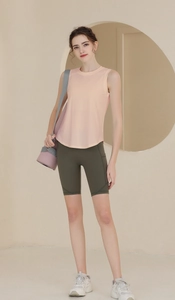 Débardeur de sport rose pêche et short de cycliste olive avec un tapis de yoga