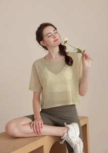 Dettaglio del top da yoga trasparente giallo chiaro con pantaloncini da ciclismo verde oliva