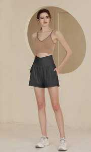 Détail du short de sport noir à taille croisée en V et du soutien-gorge de yoga marron